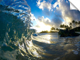 A wave breaking onto the beach during sunrise, on the north shore.