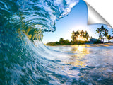 An ocean wave breaking onto the beach during sunrise, on the north shore of Oahu.